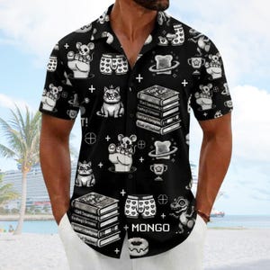 Könnte beinhalten: Ein schwarzes kurzärmeliges Hemd mit Knopfleiste und einem sich wiederholenden Muster aus pixeligen Grafiken, darunter Katzen, Mäuse, Bücherstapel mit Text, Boxershorts mit Herzmuster, Toast, Trophäen und das Wort MONGO in weißer Schrift.