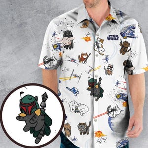 May include: White button-up shirt featuring a Star Wars theme with cartoon cats dressed as characters. The shirt has a repeating pattern of cats in various costumes, spaceships, and the Star Wars logo.