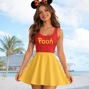 Peut inclure: Une robe sans manches avec un corsage rouge portant le mot Pooh imprimé en jaune et une jupe évasée jaune uni. La robe est accompagnée d'un serre-tête noir avec des oreilles rondes et un nœud à motif de chauves-souris orange et noir.