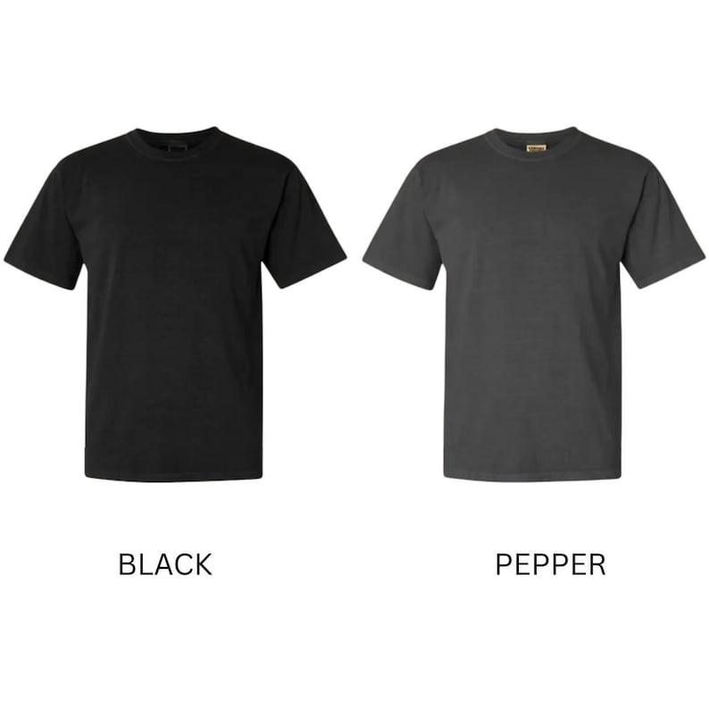 May include: Two short-sleeved t-shirts are shown, one black and one pepper-coloured. The black shirt is on the left, and the pepper-coloured shirt is on the right. The word "BLACK" is below the black shirt, and "PEPPER" is below the pepper-coloured shirt.