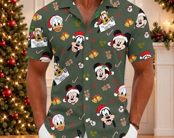 Puede incluir: Una camisa de manga corta con botones en color verde oliva que presenta un estampado integral de personajes de Disney con gorros de Papá Noel, incluyendo a Mickey Mouse, Minnie Mouse, el Pato Donald y Goofy, junto a galletas, campanas y bastones.