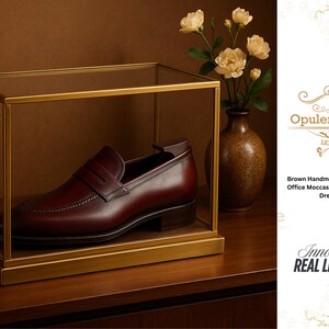 May include: A brown leather loafer displayed in a glass and gold frame. The shoe is a dress shoe with a tasseled design. The image also includes a vase with flowers and the text "Opulent Vogue Leather".