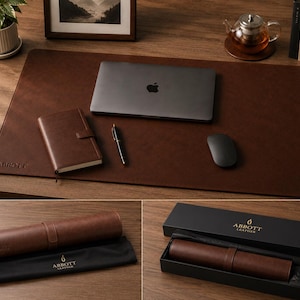 Peut inclure: Un sous-main rectangulaire en cuir marron foncé avec le texte ABBOTT embossé dans le coin inférieur gauche. Il est présenté avec un ordinateur portable, un carnet, un stylo et une souris, ainsi qu'un étui à rouleau en cuir assorti dans sa boîte.