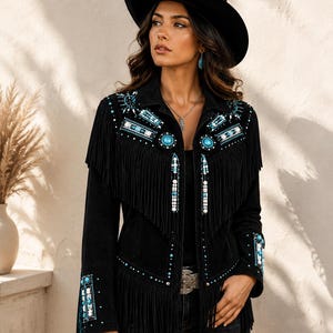 May include: A black jacket featuring long fringe detailing across the chest and sleeves. The garment is adorned with intricate beadwork in shades of turquoise, white, and silver, including circular turquoise accents and geometric patterns.