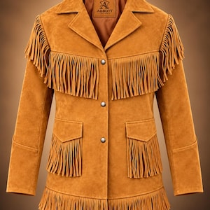 May include: A tan suede jacket featuring long fringe detailing across the chest, pockets, and hem. The jacket has a pointed collar, three silver-tone metal snap buttons down the front, and an interior label reading Abbott Leather.
