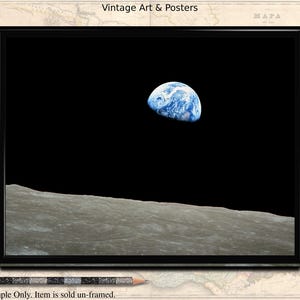 May include: A black framed print of a photograph of Earth rising above the lunar surface. The image is set against a black background. The print is 8x10 inches.