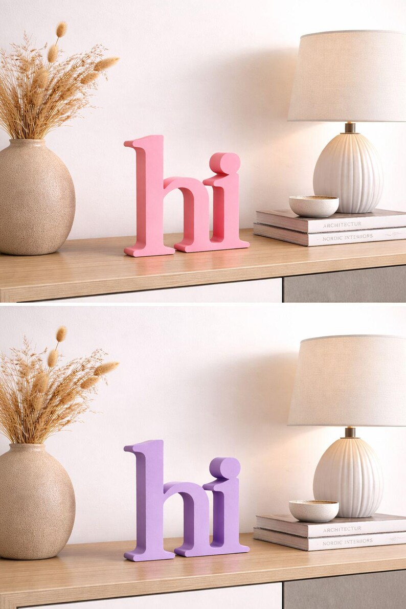 Puede incluir: Letras "hi" de madera rosa sobre una estanter&iacute;a de madera, con un jarr&oacute;n de flores secas, una l&aacute;mpara y libros. Las letras miden unos 15 cm de alto. La segunda imagen muestra las mismas letras en morado.