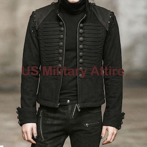 May include: Black military-style jacket with decorative buttons and a high collar. The jacket features a zip closure and detailed shoulder accents. The text "US Military Attire" is visible on the jacket.