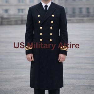 May include: A navy blue double-breasted coat with gold buttons and gold stripes on the sleeves. The coat is long and has a classic military style. The text "US Military Attire" is printed on the coat.
