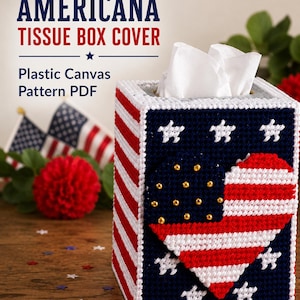 May include: A rectangular tissue box cover made of plastic canvas featuring a red, white, and blue striped pattern with white stars on a navy blue background. A heart-shaped applique with red and white stripes and gold beads is attached.