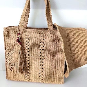 May include: A beige crochet tote bag with a matching hat. The bag features a rectangular shape, sturdy handles, and a decorative feather tassel with wooden beads. The bag has a vertical pattern with openwork details.