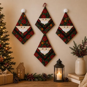 Könnte beinhalten: Vier rautenförmige Wandbehänge aus Stoff mit einem Weihnachtsmann-Gesichtsmotiv. Jedes Stück hat einen dunkelgrünen Hintergrund mit roten Weihnachtsstern-Mustern, einen weißen Filzbart, einen weißen Schnurrbart und einen weißen Bommel.