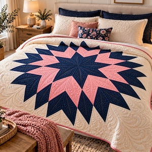 Può includere: Una trapunta da letto con un grande motivo a stella centrale in blu navy e rosa tenue, su uno sfondo color crema. La trapunta è decorata con intricate cuciture a forma di piuma su tutto il tessuto, creando un design superficiale strutturato.