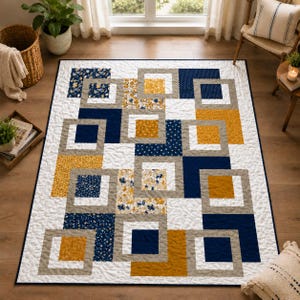 May include: A rectangular quilt featuring a geometric pattern of interlocking squares in navy blue, mustard yellow, and white. The design incorporates solid colors alongside floral and dotted prints, all framed by a white background with stitching.