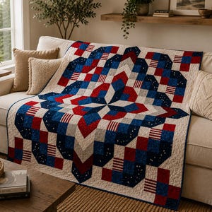 Op de afbeelding: Een quilt met een geometrisch sterpatroon in rood, wit en blauw. Het ontwerp bevat effen rode en blauwe vierkanten, witte vierkanten met subtiele patronen en secties met rood-witte strepen, allemaal gerangschikt in een symmetrische lay-out.