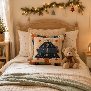 May include: A square throw pillow featuring a quilted design of a stylized Christmas tree in shades of blue, orange, and cream. The pillow is centered on a bed with a light-colored quilt, a teddy bear, and a wooden headboard in a room.