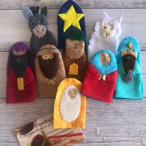 May include: Felt finger puppets depicting the Nativity scene. The set includes a donkey, a sheep, a star, Joseph, Mary, baby Jesus, and three wise men. The puppets are colourful and have embroidered details.