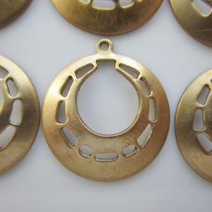 May include: Six gold-toned metal charms with a horseshoe-shaped cutout design. The charms have a smooth, slightly textured surface.