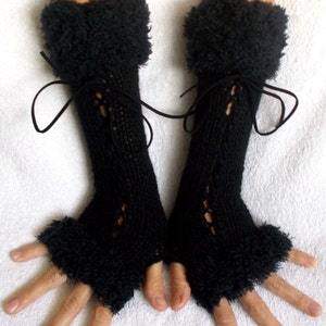 May include: Black fingerless gloves with a fuzzy trim and lace detail. The gloves have a tie at the wrist.