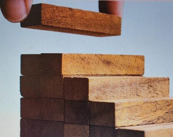 May include: A book cover with the title "The Power of SMART Goals" and the subtitle "Unlock Your Potential for Lasting Change". The cover features a hand placing a wooden block on top of a tower of wooden blocks, creating a staircase shape. The author's name, "Alex Walchak", is printed at the bottom of the cover.