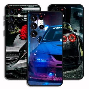 Op de afbeelding: Drie telefoonhoesjes met autodesigns. De hoes aan de linkerkant heeft een zwarte auto met een boeket rode rozen. De middelste hoes heeft een blauwe auto met de tekst "ITS RUDE". De hoes aan de rechterkant heeft een zwarte auto met rode achterlichten.