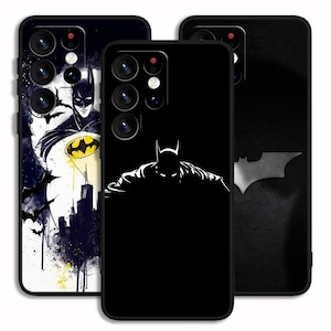 Op de afbeelding: Drie telefoonhoesjes met Batman-ontwerpen. Eén hoesje heeft een Batman-illustratie met een geel vleermuissymbool, een ander heeft een silhouet van Batman en de derde heeft een Batman-logo.