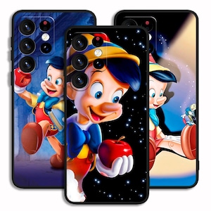 Può includere: Tre custodie per telefono con il personaggio di Pinocchio del film Disney. Le custodie hanno sfondi diversi, tra cui una notte stellata e uno sfondo blu. Pinocchio tiene in mano una mela in una custodia.