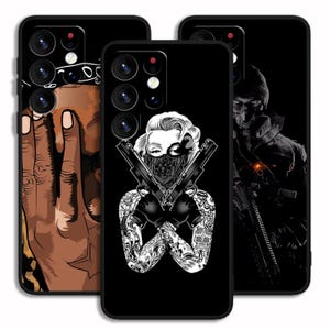 May include: Three black phone cases with unique designs. One features a hand with a bandana, another depicts Marilyn Monroe with guns and tattoos, and the third showcases a figure in tactical gear. Each case has a glossy finish.