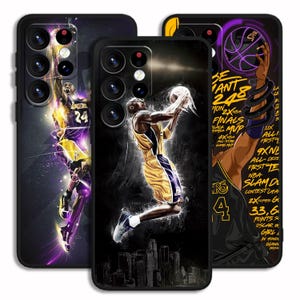 May include: Three black phone cases with basketball-themed designs. One case depicts a player in a yellow and purple uniform, mid-jump with a basketball. Another case displays the number 24. The third case has text and a basketball graphic.