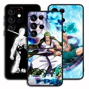 以下が含まれることがあります： アニメのキャラクターが描かれた黒い携帯電話ケース3つ。1つは剣士の白いシルエット。もう1つは緑色の髪と剣を持つキャラクター。3つ目は青い背景のキャラクターです。