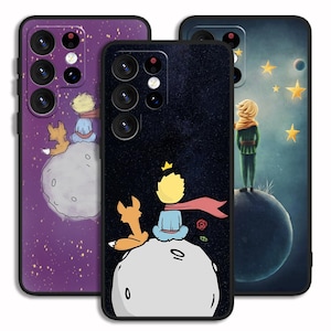 May include: Three phone cases with a purple, black, and blue background. Each case features a cartoon illustration of The Little Prince with a fox and a star-filled night sky.