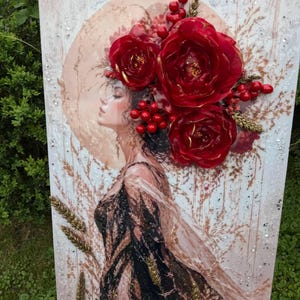 May include: A rectangular wall art piece featuring a profile illustration of a person with long dark hair adorned with large three-dimensional red flowers, red berries, and gold wheat stalks. The background is a soft beige with subtle botanical patterns.