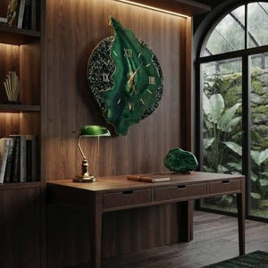 May include: A large, irregular, green wall clock with gold Roman numerals and hands, featuring a textured, dark, speckled border. The clock is mounted on a dark wood paneled wall above a wooden desk with three drawers, a green lamp, and a green stone.