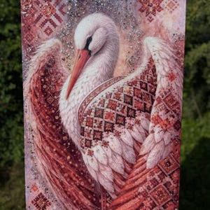 May include: A rectangular wall art piece featuring a white stork with an orange beak, set against a background of intricate red and pink geometric patterns. The artwork is embellished with silver glitter accents throughout the composition.