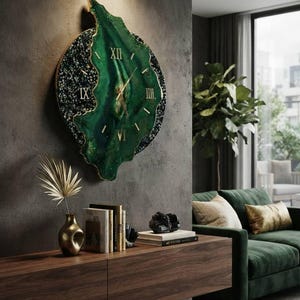 May include: A large, irregular wall clock featuring a deep green, marbled resin face with gold-colored Roman numerals and thin gold hands. The outer edge is textured with dark, crushed stone-like accents and a thin gold metallic border.