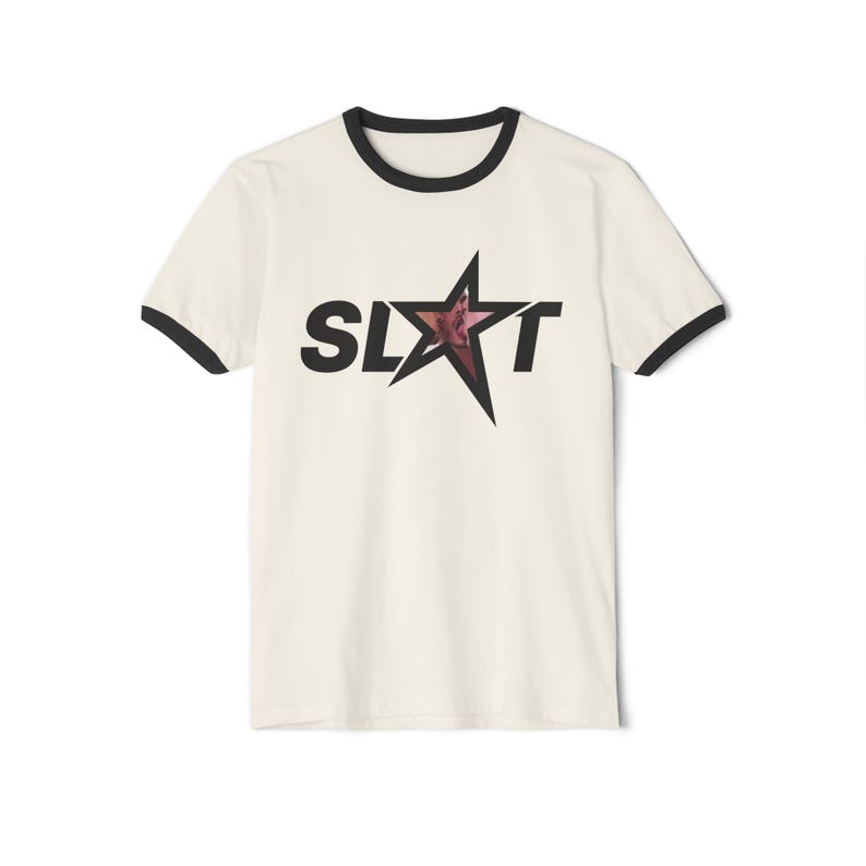 Puede incluir: Camiseta ringer color crema con ribetes negros en cuello y mangas. Presenta la palabra "SLXT" en letras negras con una estrella en el centro. La estrella tiene un dise&ntilde;o degradado en rojo y rosa. Prenda casual.