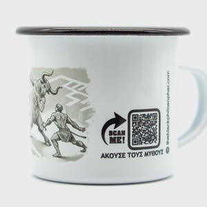 Puede incluir: Taza de esmalte blanco con borde y asa negros. La taza presenta una ilustración en escala de grises de un hombre luchando contra un toro, con un laberinto en el fondo. Incluye un código QR con el texto "SCAN ME!" y texto griego.