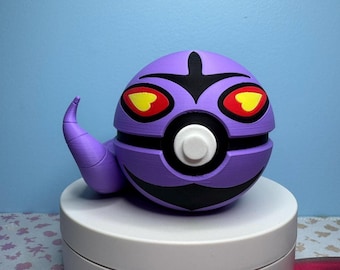 May include: A purple, spherical 3D-printed figure with black accents and a curved tail. The figure has large red eyes with yellow centers and a white circular button on the front. The figure is sitting on a white platform.