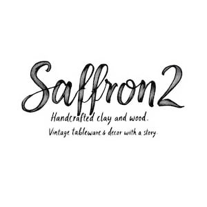 May include: A white background with the black text "Saffron 2". Below the name are the words "Handcrafted clay and wood." and "Vintage tableware & decor with a story."