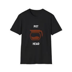 Può includere: T-shirt nera con grafica di caffettiera marrone e le parole "POT" e "HEAD". Il design della caffettiera include un manico e una forma curva, con un liquido color caffè all'interno.