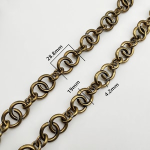 May include: Two antique brass-colored chains with interlocking circular links. The links measure 28.8mm, 19mm, and 4.2mm. The chains are displayed on a white background. The chains are likely used for jewelry or craft projects.