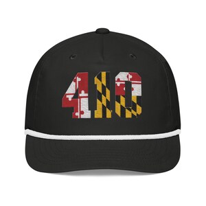 May include: Black baseball cap featuring the number "410" embroidered in the Maryland state flag design. The cap has a white rope detail along the brim and a curved visor. A stylish accessory.