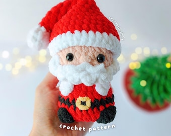 Puede incluir: Un pequeño muñeco de Santa Claus hecho a ganchillo con hilo suave rojo, blanco, negro y color melocotón. La figura presenta un gorro rojo con borde blanco, barba blanca, ojos negros y un traje rojo con cinturón negro y hebilla amarilla. Texto: crochetbythaly y crochet pattern.