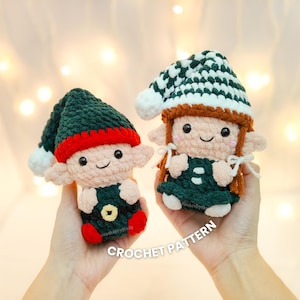 May include: Two crocheted elf dolls with smiling faces, wearing green outfits and hats. One elf has a red and green hat, the other has a green and white hat. The dolls are handmade and have small ears.