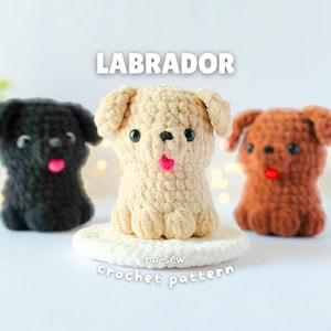 Op de afbeelding: Drie kleine Labrador hondjes gemaakt van pluche garen met haaktechnieken. De middelste figuur is crème, de linker is zwart en de rechter is bruin. Elk heeft zwarte kraaloogjes en een klein roze tongetje. Tekst: LABRADOR no-sew crochet pattern.