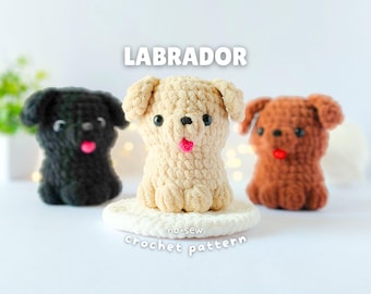 May include: Three small Labrador dog figures made of plush yarn using crochet techniques. The center figure is cream, the left is black, and the right is brown. Each has black bead eyes and a small pink tongue. Text reads LABRADOR no-sew crochet pattern.