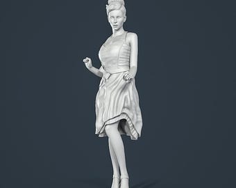 Può includere: Scultura bianca di una donna con un abito e tacchi in stile vintage. La figura è in posa dinamica, con un braccio alzato e l'altro piegato. L'abito presenta una vita con cintura e una gonna fluida. La scultura è su una base rotonda.