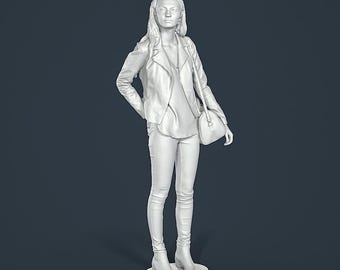 Può includere: Scultura bianca di una persona con giacca, camicia, jeans e stivali, con una borsa a tracolla. La figura è in piedi su una base rotonda e bianca. La giacca è aperta.
