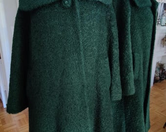 May include: Two green fuzzy coats with a large collar and a single button closure. The coats are on mannequins and are displayed against a light wood floor.