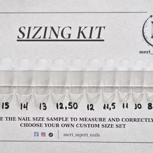 Könnte beinhalten: Ein Größen-Set für künstliche Fingernägel mit einer Reihe durchsichtiger Kunststoff-Nagelspitzen auf einer weißen Karte. Die Karte zeigt den Text SIZING KIT, den Markennamen meri_mperi_nails und die Zahlen 16 bis 7 unter jeder Nagelgröße.